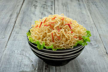 Instant noodle in the bowl on wooden background