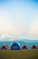 Four camping tent set on grass floor with beautiful view of Green mountain background