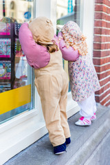 Boy and girl puppet peek through shop window