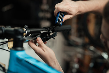 A young guy repairs a bicycle.