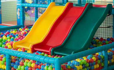 Children playground with plastic slides and colorful balls in pool