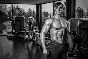 Fototapeta na wymiar Sexy muscular man posing in gym, shaped abdominal. Strong male n