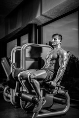 Fototapeta na wymiar Leg Exercises - Man Doing Leg With Machine In Gym