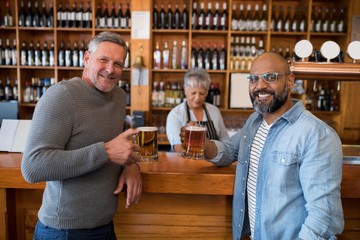 Two men having glass of bear at counter in restaurant