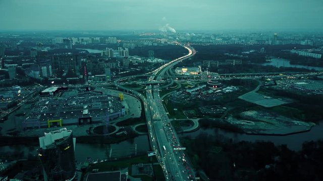 Aerial shot of big city highways intersection. Huge traffic jams near shopping malls in the evening rush hour
