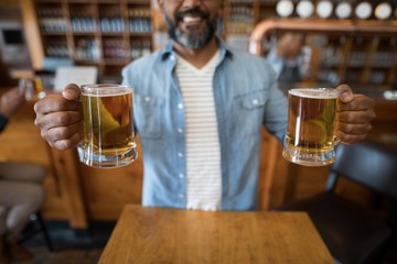 Smiling man having glasses of beer in restaurant