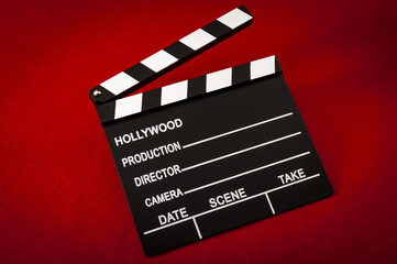 Obraz premium Hollywood and the movie industry concept with a vintage movie clapper board on red background