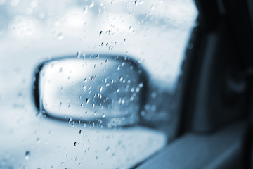 Raindrops on the car rearview mirror, selective focus
