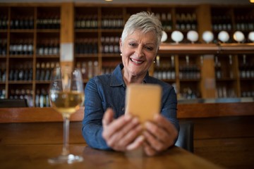 Senior woman using mobile phone in restaurant