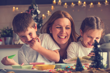Mother with children having fun preparing for Christmas holidays. Joy and happiness