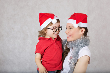 Obraz premium Mother and a son dressed in Santa Claus hats