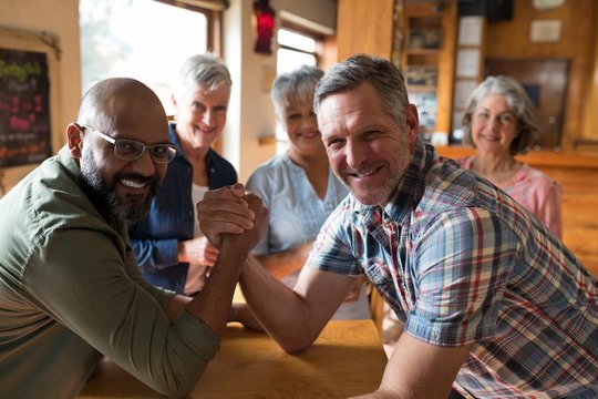 Happy friend arm wrestling each other