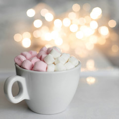 Cup of hot chocolate and marshmallow in the background of Christmas decorations.