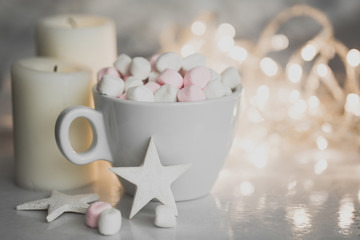 Cup of hot chocolate and marshmallow in the background of Christmas decorations.