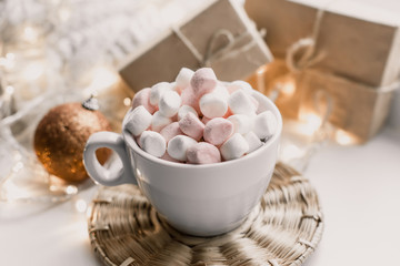 Fototapeta na wymiar Cup of hot chocolate and marshmallow in the background of Christmas decorations.