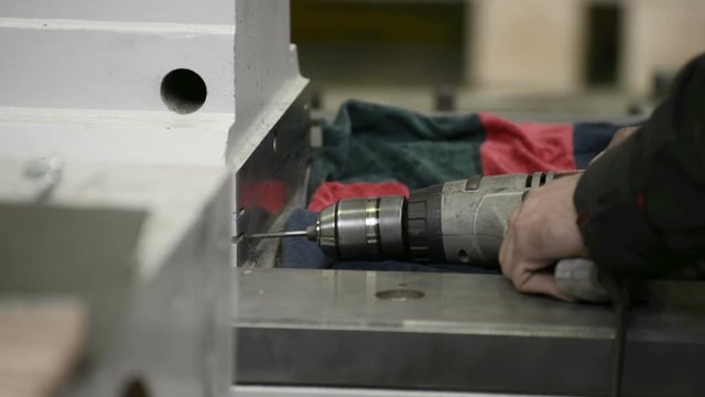 Drilling holes in a metal surface using a hand-held electric drill
