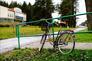 Bicycle with basket parked near urban railings, outdoors