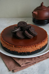 Chocolate cheesecake with cookies on a white plate.