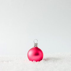 Creative layout made of Christmas bauble decoration on snow. Holiday background.