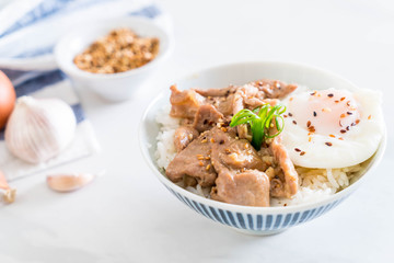 stir-fried pork with garlic on topped rice with egg