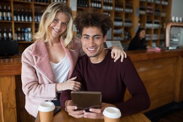 Couple using digital tablet in bar