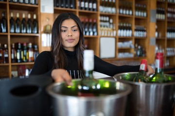 Waitress looking at bucket of beer bottle