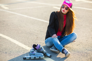 Outdoor fashion closeup portrait of nice pretty young hipster woman posing in sunglasses at sunset walks along the streets of the city.