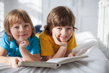 two boy read book indoors