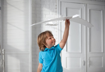 happy boy play with airplane in hand, child dreams about traveling by aeroplane