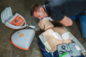 The use of an automatic external defibrillator in conducting a basic cardiopulmonary resuscitation to the victim on the street - obrazy, fototapety, plakaty