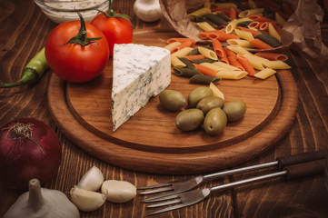 Food ingredients for preparing pasta on rustic kitchen table