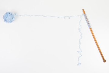 Knitting needles and blue yarn ball on white background as frame with copy space for text