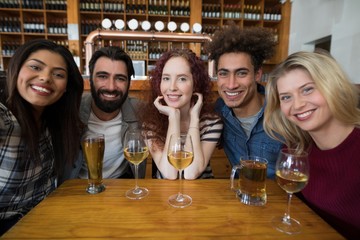Happy friends sitting together in bar
