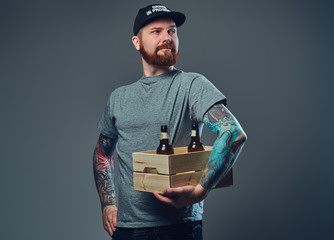 A man holds a wooden box with beer bottles.