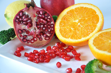 Pomegranate and Fresh Orange on White Plate