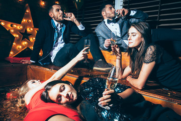 Friends at club lying on the floor and cheers after party having fun