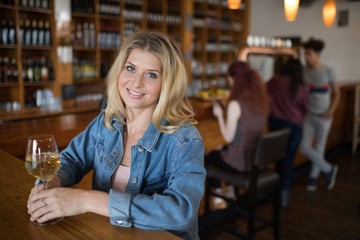 Smiling beautiful woman having wine at counter