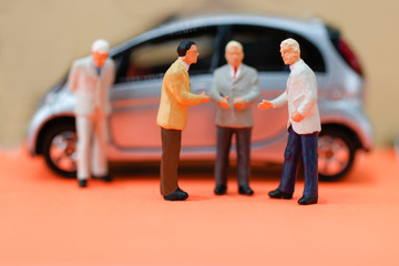 Miniature businessman handshake with car, agreement, investment, partnership and business concept