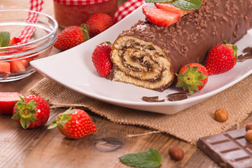 Chocolate roll with hazelnuts and strawberries. 