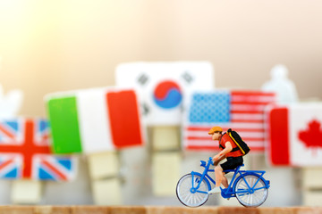Miniature traveler with bicycle  on the world map. Travel and Sport concept.