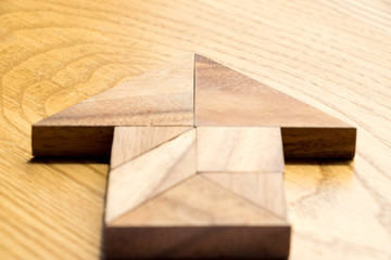 Wood tangram puzzle in arrow that point the forward direction shape