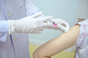 Soft focus nurses are vaccinations to patients using the syringe.Doctor vaccinating women in...