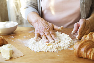 Elderly woman cooks french croissants, bare wrinkled hands, ingredients, soft warm morning...