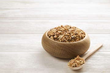 Granola superfood with almond and cashew nuts, dry fruits, raisins cherry  in wooden bowl on the white wooden table, top view, bright light  Text space.