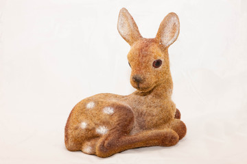Fototapeta na wymiar statue of a sitting fawn looking at the camera