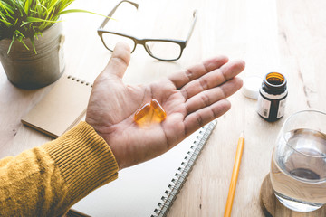 Male eating medicine,pill (vitamin) on work in morning.healthy lifestyle concepts