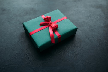 Christmas present in a red gift box on grey background. Festive season concept