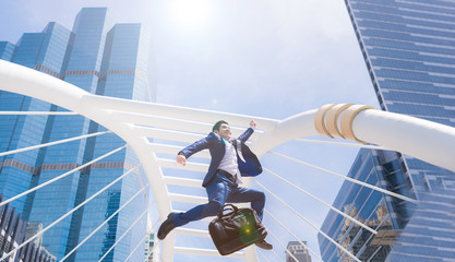 Successful businessman jumping with city town background.
