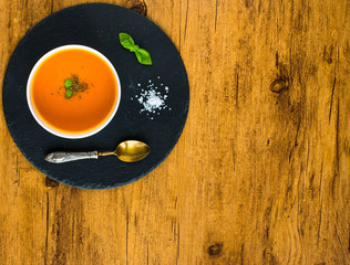 Homemade Pumpkin Soup on rustic wooden background, free space for text.