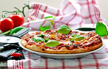 Pizza with salami, chili and basil